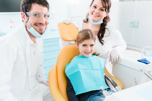 kid with dentist and mother