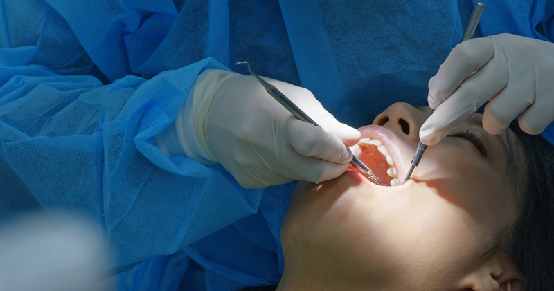 Woman under dental extraction in clinic