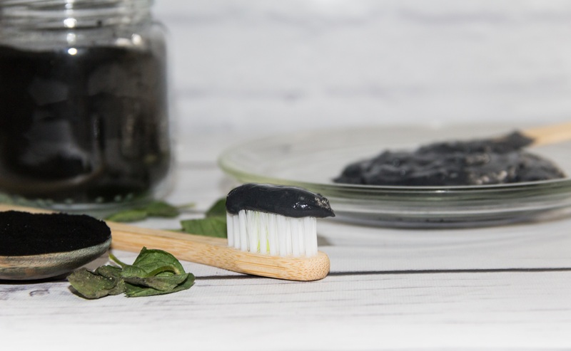 a toothbrush with charcoal toothpaste