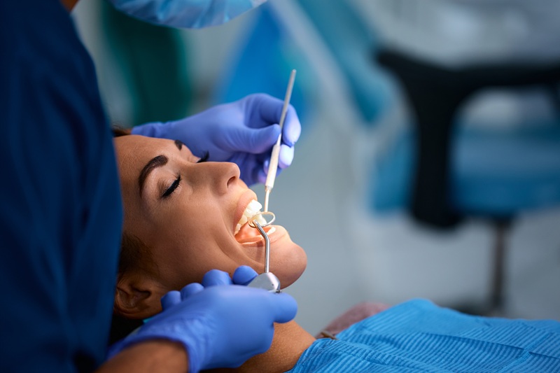 Young woman getting her teeth check for dental extraction by dentist at dental clinic.