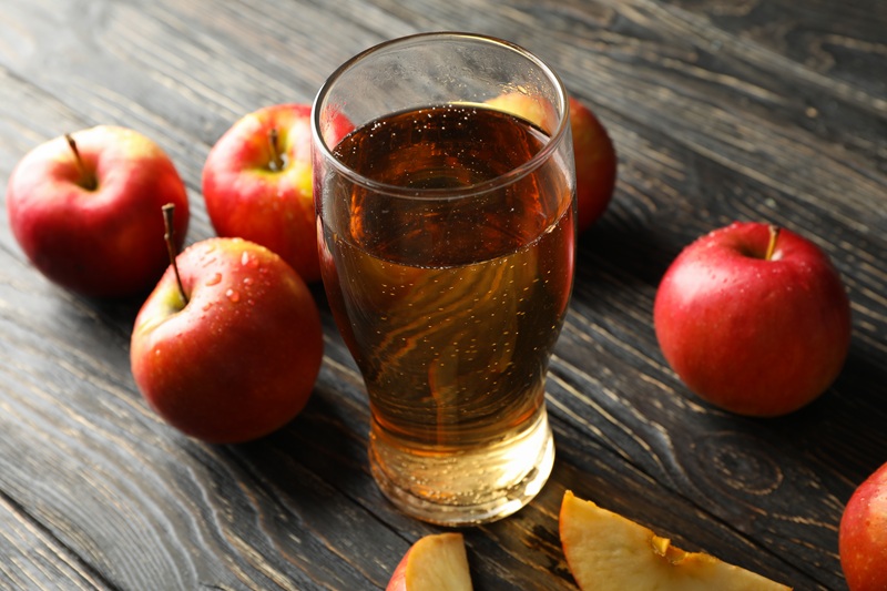 Composition with cider and apples on wooden background