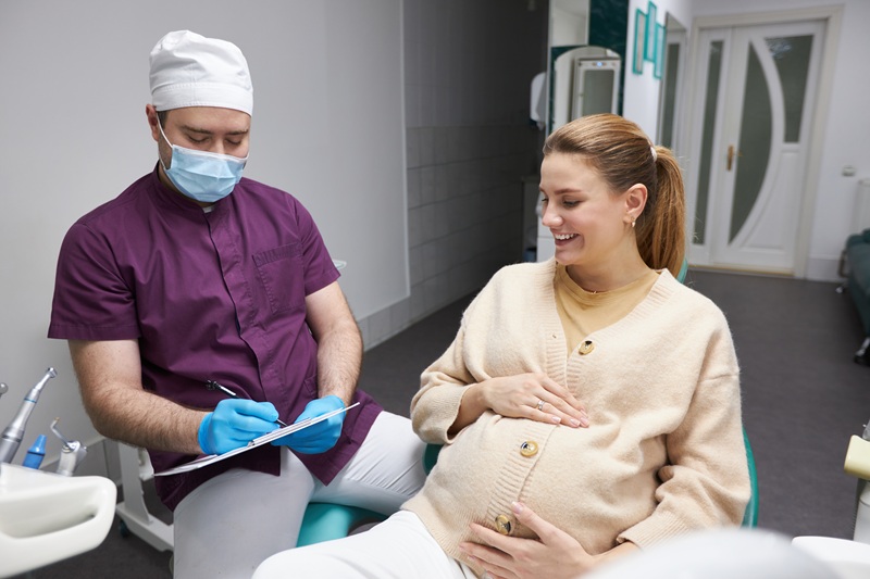 Dentist doctor prescribes a treatment after the examination of the oral cavity of a pregnant woman in a modern dental office. Dentistry. Healthcare and medicine. People. Service. Consumerism